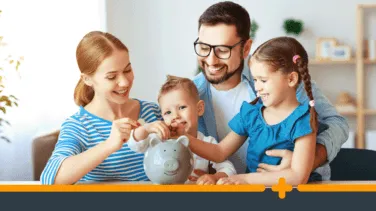 Uśmiechnięta rodzina wrzuca monety do skarbonki w kształcie świnki