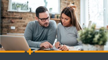 Zamartwiona para omawia formalności finansowe przy komputerze